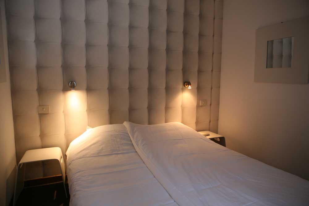 Slaapkamer op het tussenverdiep met dubbelbed en stapelbed en badkamer